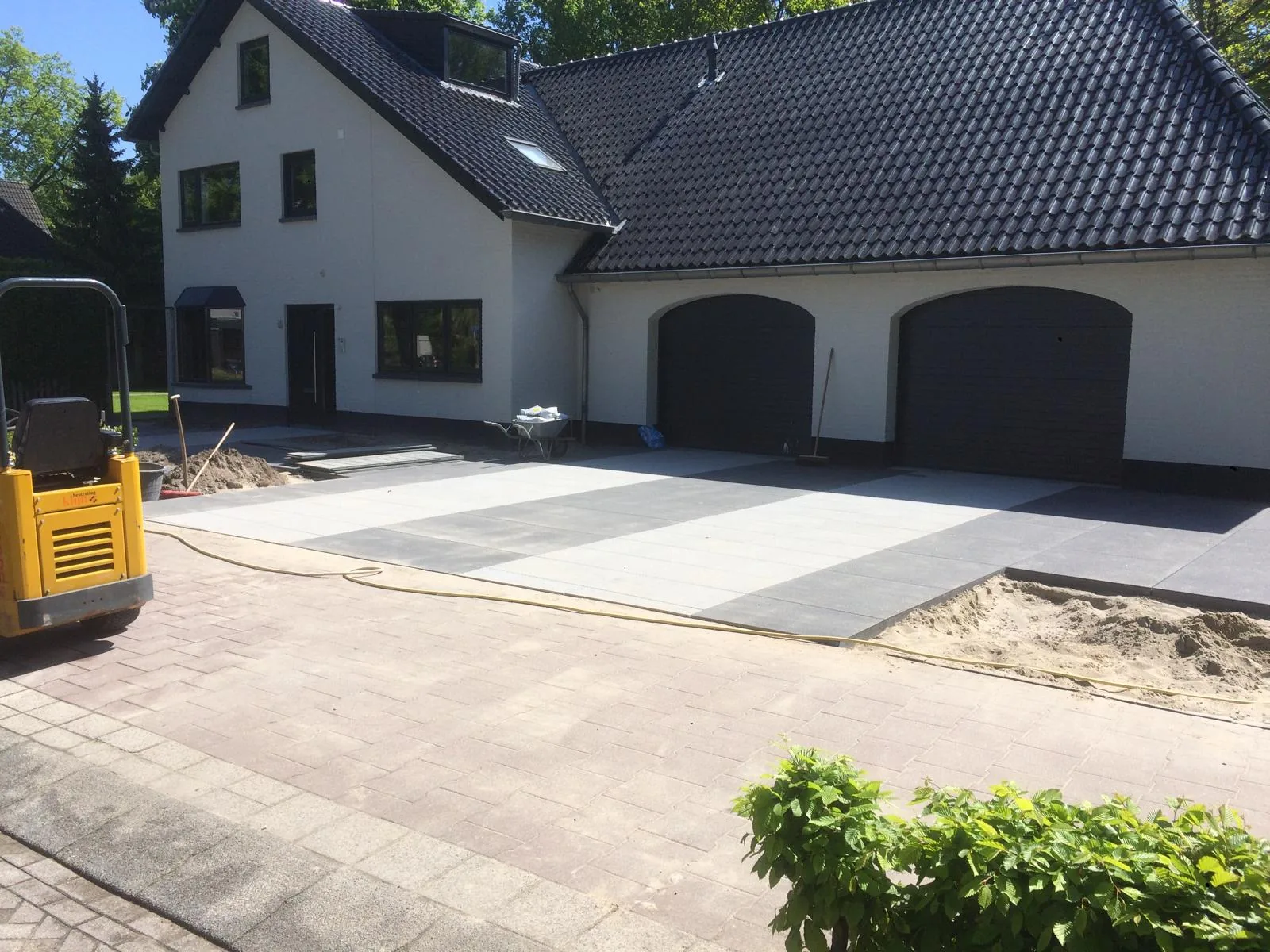 Oprit in grootformaat betontegels in twee tinten grijs