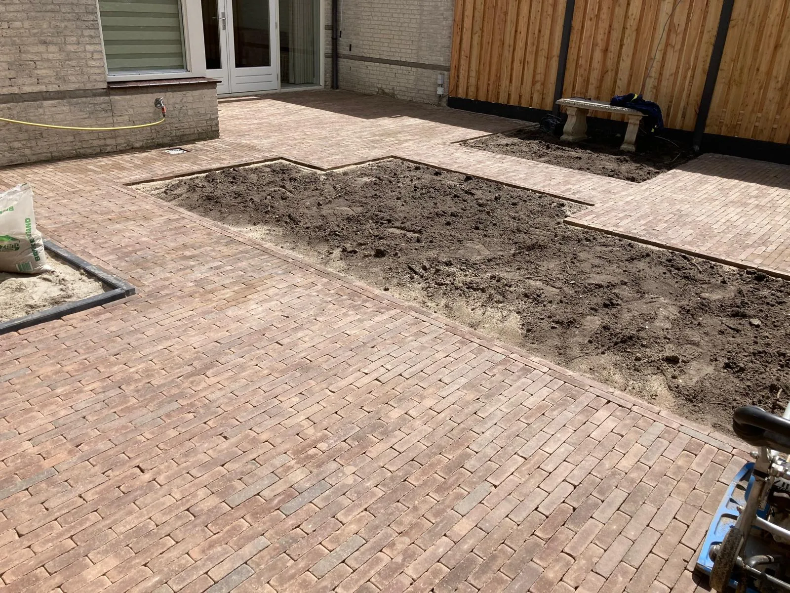 Binnenplaats in gebakken klinkers met uitgespaarde plantvakken