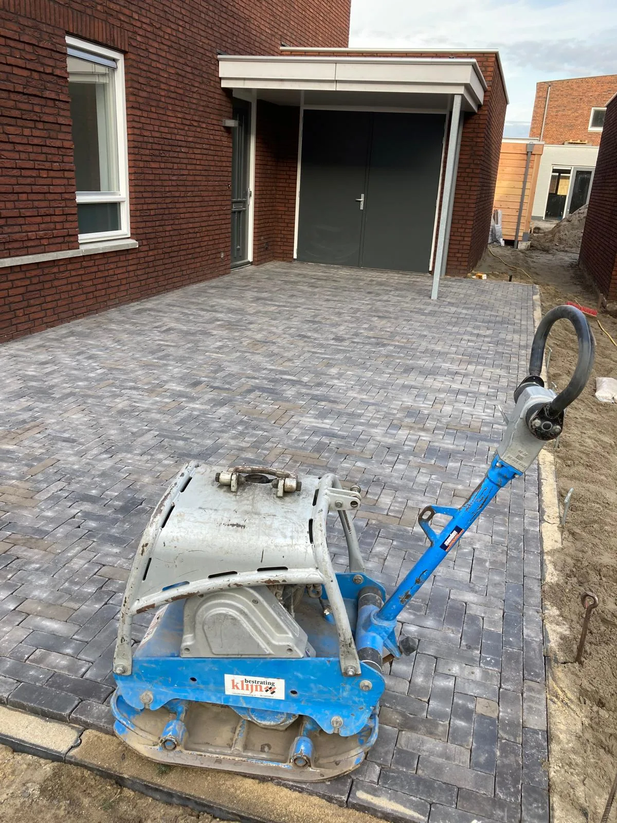 Oprit in gebakken klinkers die met de trilplaat wordt afgewerkt