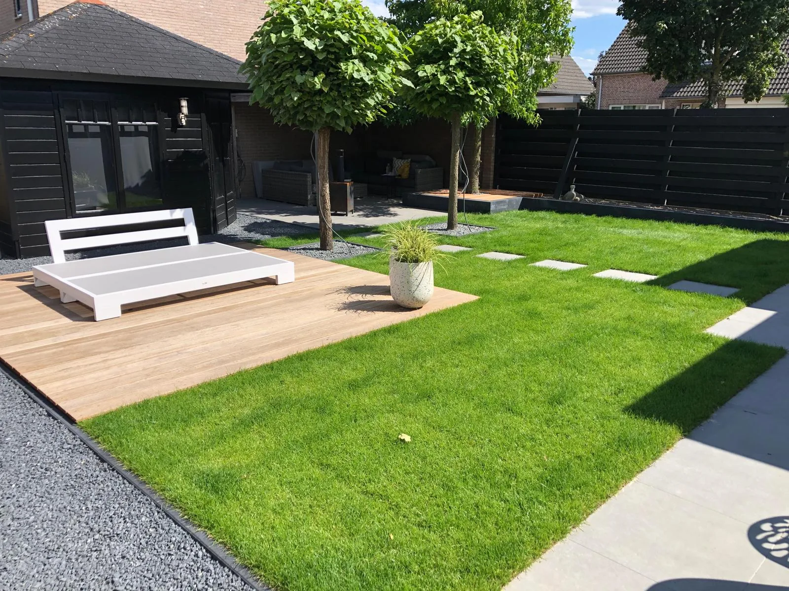 Complete tuinaanleg met houten vlonder, gazon en stapstenen