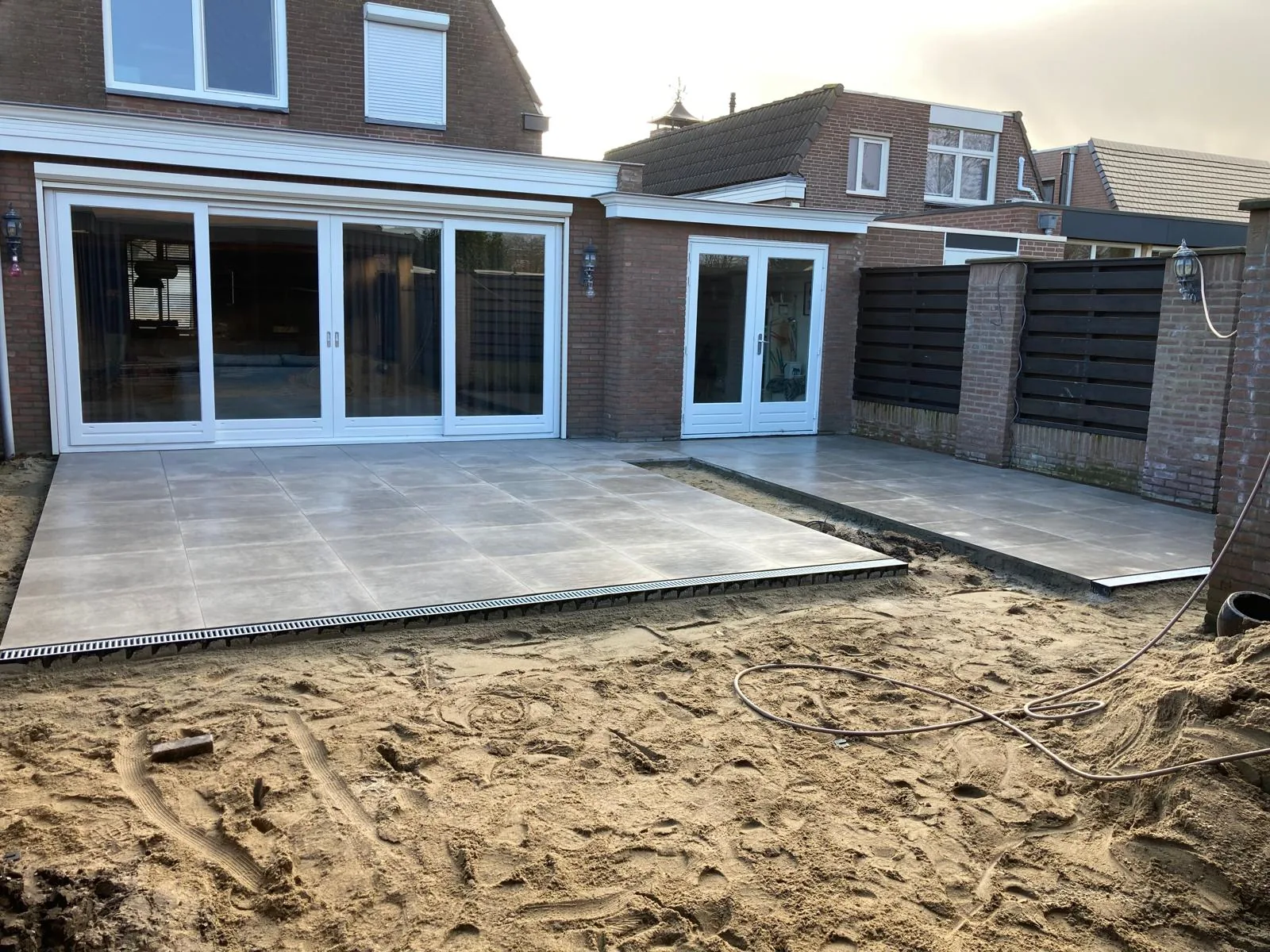 Terras in grootformaat keramische tegels met lijngoot, tijdens de aanleg