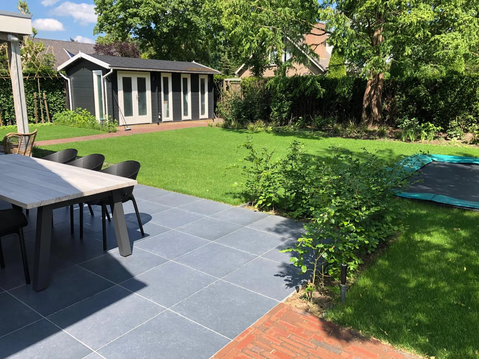 Terras met grootformaat keramische tegels en eettafel